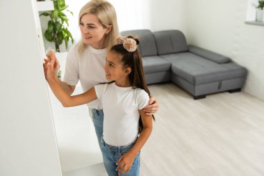 Oturma odasındaki duvara dijital dokunmatik ekran panelle evi kontrol etmek. Evdeki akıllı aygıtları yönetmek için akıllı ev ve mobil uygulama kavramı