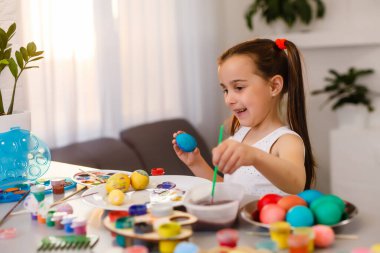 Paskalya yumurta boyamak için küçük kız eğleniyor