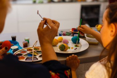 Büyükanne torunu ile olan boyama yumurta Paskalya için.