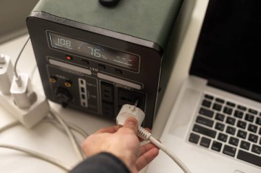 Portable power station charging gadgets on table in room