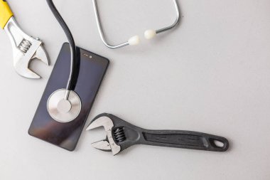 Cell phone repair. Smartphone parts and tools for recovery, selective focus Phone repair and service concept.Smartphone being diagnosed with a stethoscope