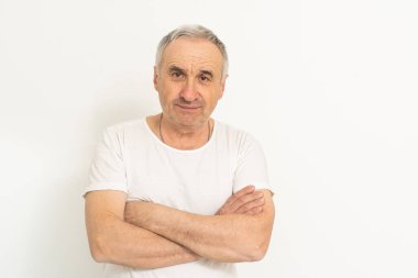Elderly Caucasian man with white hair smiling on gray background