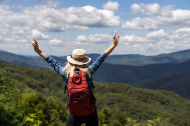 Sırt çantalı kadın. Dağdaki manzaranın tadını çıkar..