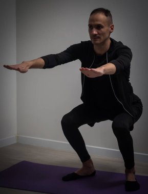 Full size portrait of active, athletic, sporty, attractive, confident, concentrated guy is doing exercises.