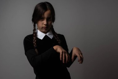 Cadılar Bayramı. Takım elbiseli bir kız. Tatil günü. Hallowmas. Çarşamba Addams. Addams Ailesi. Reenkarnasyon. Kostümlü. Cadılar Bayramı için fikir. Bir kızın portresi.