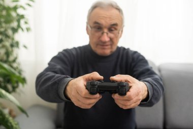 Portrait of elderly man playing video games.