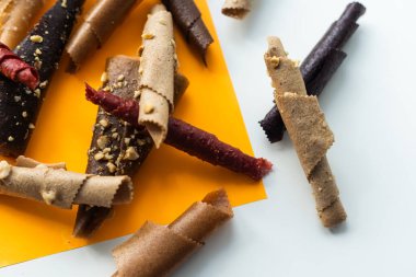 meyve ruloları portakal, mango, muz sarı arka planda yakın plan.