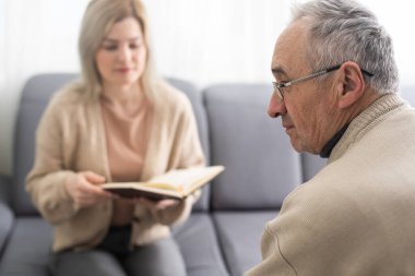 Endişeli, ciddi, yaşlı bir adam hastanede kadın doktoru dinlerken, terapist, olgun bir hastaya hastalık, tedavi, yaşlı nesil sağlık konsepti hakkında danışmanlık yapıyor..