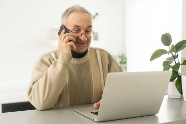 Yakışıklı, gülümseyen, gözlüklü, cep telefonu takan, evinde bilgisayarlı rahat iş yerinde oturan, emekli, sosyal medyada arkadaşlarıyla sohbet eden, akıllı telefondan yazan...