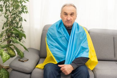 Ukrayna bayrağı taşıyan kıdemli bir adam. Ukrayna ulusal bayrak renkleri. Ukrayna için dua et, savaşı durdur, Ukrayna halkını ve çocuklarını kurtar. İstila, işgal ve terörizm yok