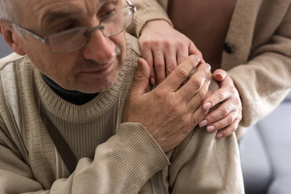 Two people holding hand together. elderly man and support woman.