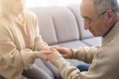 Senior couple, happy and laughing in their home with love, care and support for retirement lifestyle. Commitment of a funny man and woman in a marriage with trust and security on a living room couch