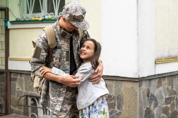stock image Little child is very happy her father came back from army. Little kid is hugging her father.
