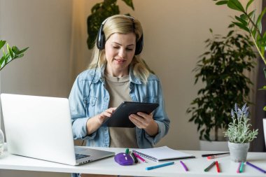 Çekici pozitifin fotoğrafı. Masaüstüne otur. Bilgisayarı kullan..