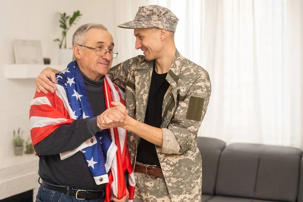 an elderly father and a military son, American flag.