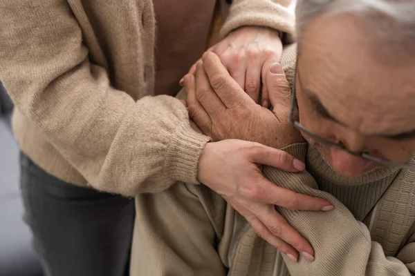 Genç fizyoterapistle rehabilitasyon işlemine katılan yaşlı bir erkek emeklinin başından vurulmuş. Yürüme engelli emekli bir adam profesyonel yardıma minnettar.