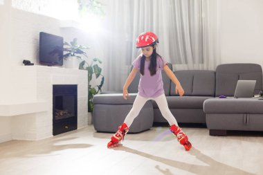 Caucasian little girl in roller skates standing at the living room.