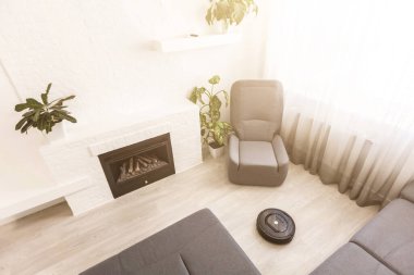 Oturma odasındaki lamine ahşap zeminde robotik süpürge.