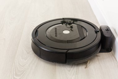 Robot elektrik süpürgesi odayı temizliyor.