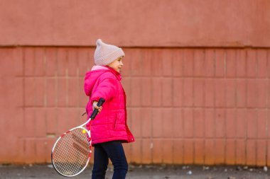 Tenis oynayan küçük tatlı bir kızın portresi.