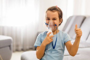 Küçük kız evde nebulizörle solunum yapıyor. çocuk astım spreyi soluma nebulizer buhar tutması öksürük konsepti yatay
