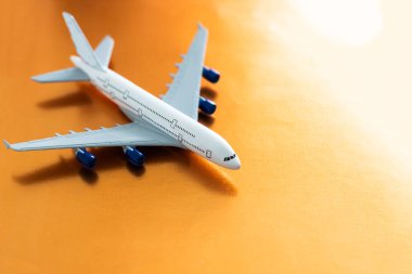 Airplane model. White plane on orange background. Travel vacation concept. Summer background. Flat lay, top view, copy space