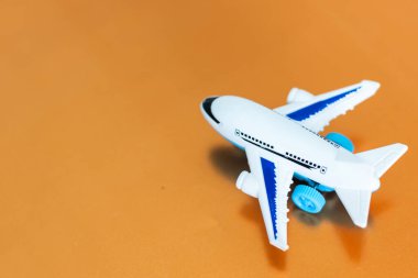Uçak modeli. Turuncu arka planda beyaz bir uçak. Seyahat tatili konsepti. Yaz dönemi. Düz konum, üst görünüm, kopyalama alanı