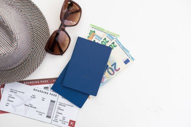 Beyaz arka plan görünümlü pasaport ve şapkalı turistik şeyler.