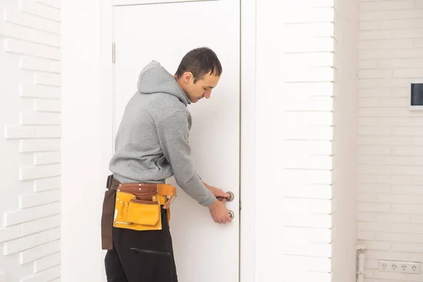 Young Handyman Installing White Door Room — Zdjęcie stockowe