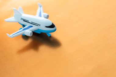 Airplane model. White plane on orange background. Travel vacation concept. Summer background. Flat lay, top view, copy space
