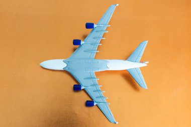 Turuncu arka planda küçük beyaz uçak