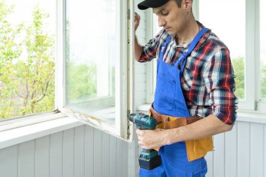 İnşaat işçisi eve pencere kuruyor.