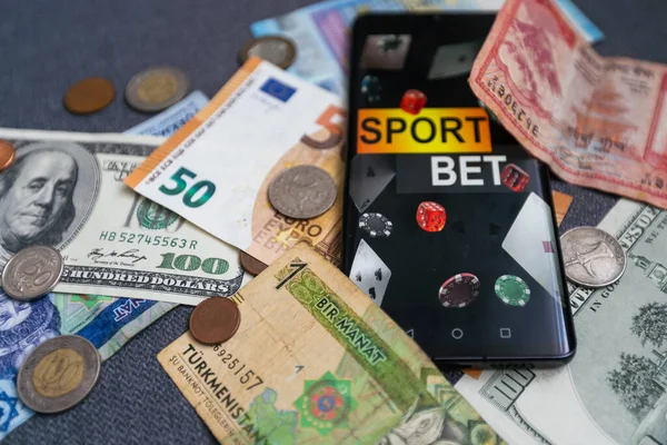 dollars and euros, smartphone with sports bet application.