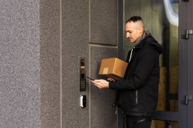 Adam evinin kapı açmak için smartphone kullanır