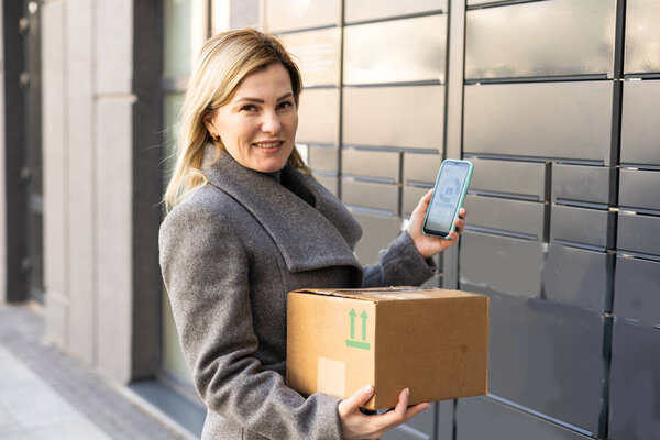 Красивая женщина забирает посылку из смарт-электронного ящика для посылок, автоматические почтовые ящики. Упаковка при доставке, инкассаторская машина.