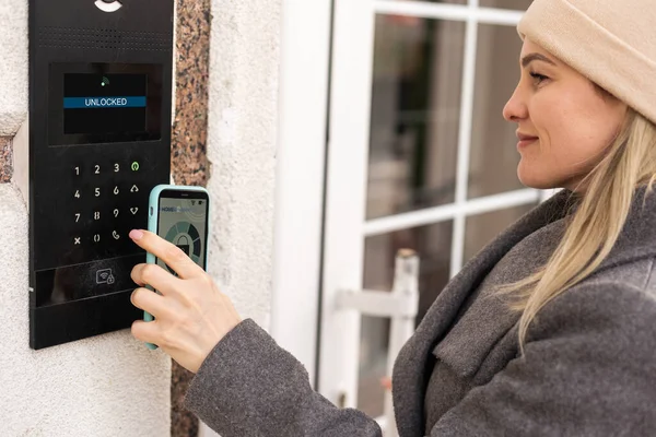Woman hands using phone scan to digital door lock security systems at home.