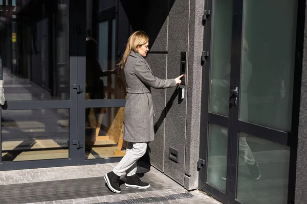 Bir Kadın Akıllı Telefon Kullanarak Giriş Kapısına Akıllı Kilit Takıyor — Stok fotoğraf