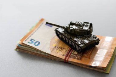 Ekonomik kriz konsepti. Avro banknotları üzerinde oyuncak askeri tank. Ukrayna 'daki savaş çatışmaları, ekonomik yaptırımlar ve enflasyon.