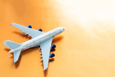 Turuncu arka planda küçük beyaz uçak