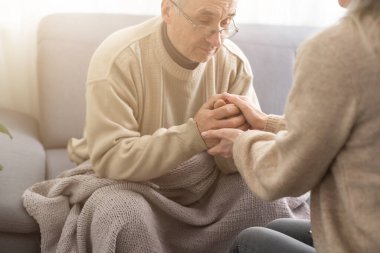 Senior couple, happy and laughing in their home with love, care and support for retirement lifestyle. Commitment of a funny man and woman in a marriage with trust and security on a living room couch