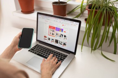 Kyiv, Ukrayna - 17 Mart 2023: Aliexpress logosuna sahip dizüstü bilgisayarı olan kadın.