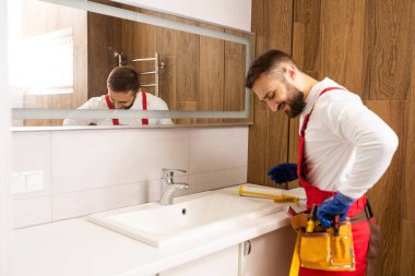 a worker installs a wash basin in a bathroom