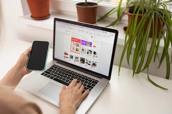 Kyiv, Ukrayna - 17 Mart 2023: Aliexpress logosuna sahip dizüstü bilgisayarı olan kadın.