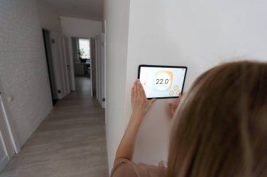 Denetim ev bağlantısı arabirimi için akıllı telefon kullanan kadın.