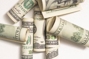 roles dollar notes in front of white background.