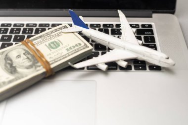 uçak, para ve klavye. Gri ahşap bir masada internet üzerinden uçak bileti almak..
