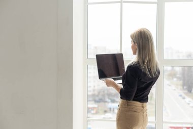 Ofiste dizüstü bilgisayarla çalışırken gülümseyen güzel bir kadın resmi