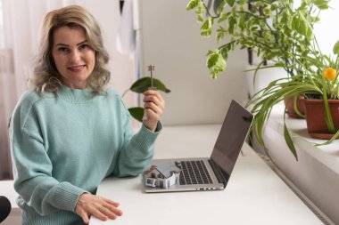 Elinde model ev, emlak sigortası ve bankacılık konsepti olan genç bir kadının elleri