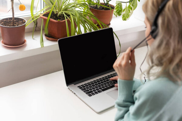 Young confident fun successful employee business woman in casual blue shirt stand work at workplace white desk with laptop pc computer browsing at light modern office indoor Achievement career concept