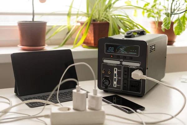 Portable power station charging gadgets on table in room